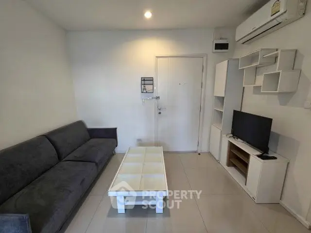 Modern living room with sleek furniture and minimalist design, featuring a comfortable sofa and wall-mounted TV.