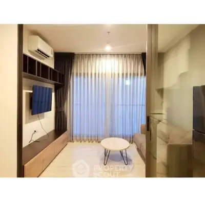 Modern living room with sleek furniture and large window, perfect for cozy evenings.