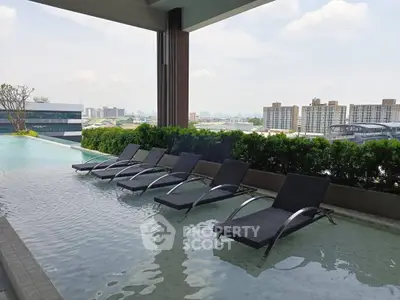 Luxurious rooftop pool with city skyline view and stylish sun loungers, perfect for relaxation and leisure.