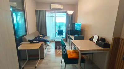 Modern living room with balcony view, stylish furniture, and natural light.