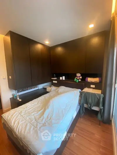 Modern bedroom with sleek wooden cabinetry and cozy bed