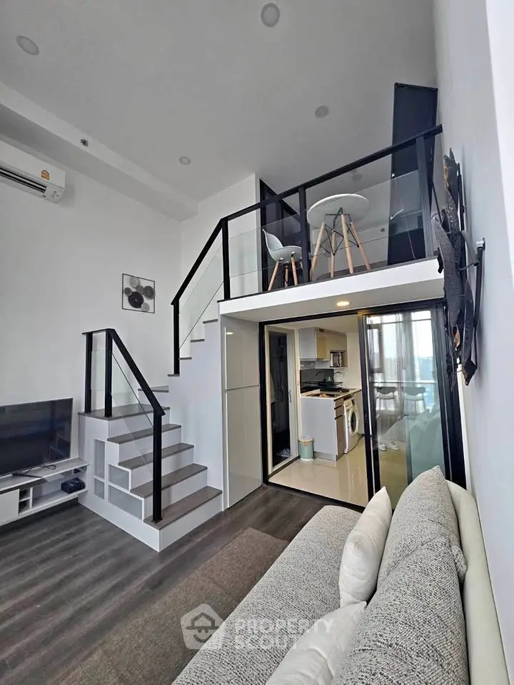 Modern loft apartment with mezzanine, sleek staircase, and open living area.