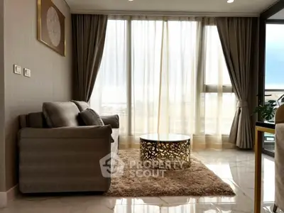 Elegant living room with plush sofa, stylish coffee table, and floor-to-ceiling windows offering natural light.