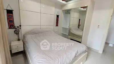 Spacious bedroom with modern decor and large mirrored wardrobe
