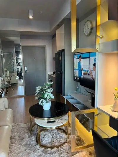 Modern living room with stylish decor and open layout, featuring a cozy seating area and sleek TV setup.