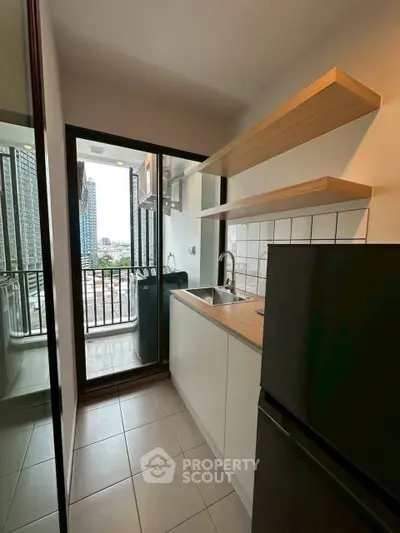 Modern kitchen with balcony view in high-rise apartment