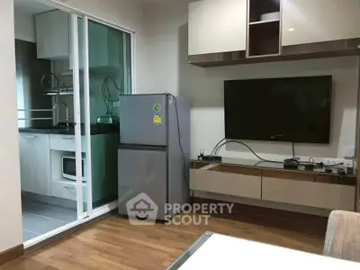 Modern living room with sleek kitchen and stainless steel fridge