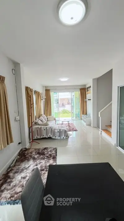 Spacious living room with modern decor and large windows opening to a balcony, perfect for natural light.