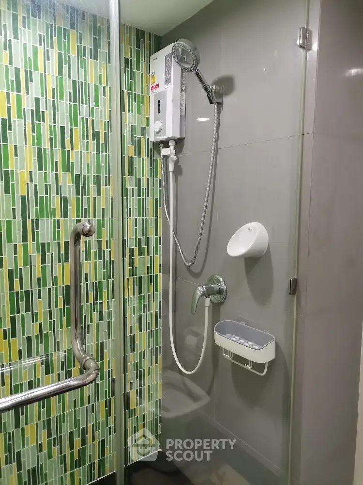 Modern bathroom shower with vibrant green mosaic tiles and sleek fixtures