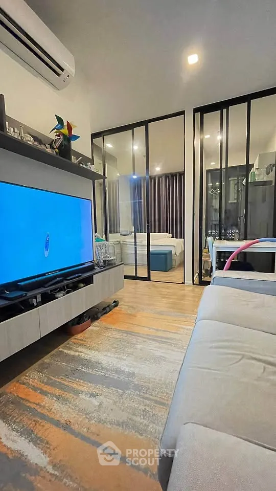 Modern living room with sleek glass partitions and cozy furnishings
