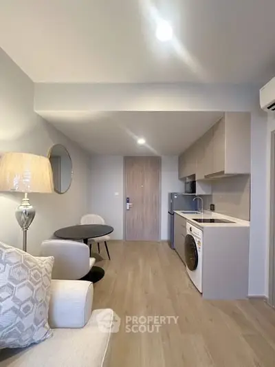 Modern open-plan living room with sleek kitchen and stylish decor in a contemporary apartment.