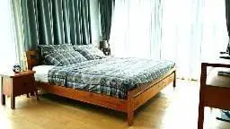 Spacious bedroom with large windows and elegant wooden furniture