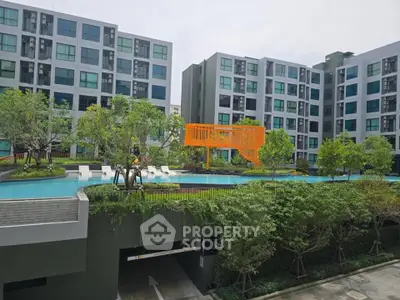 Modern apartment complex with pool and lush greenery, offering a serene urban living experience.