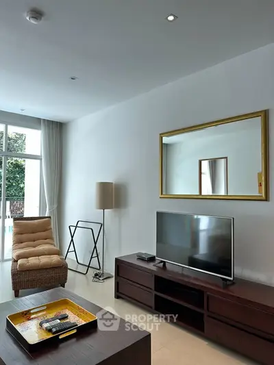 Spacious living room with modern decor and large TV, perfect for relaxation.