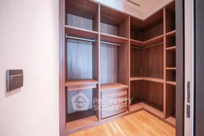 Spacious walk-in closet with wooden shelves and drawers in modern home.