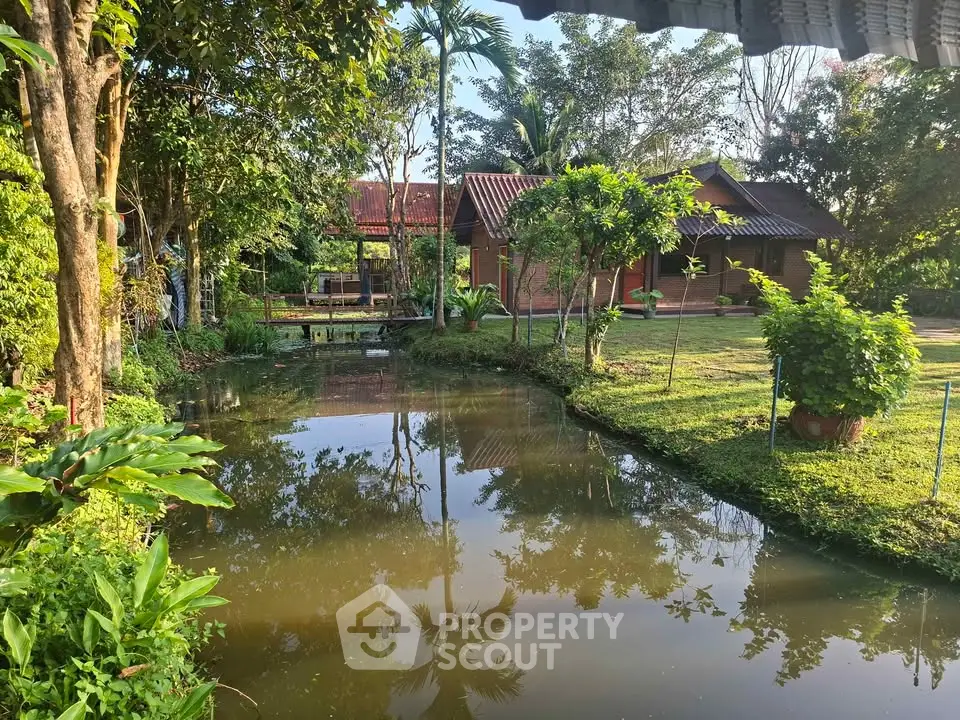 Charming countryside property with lush garden and serene pond view.