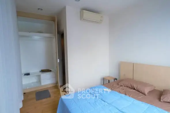 Cozy bedroom with blue bedding and open closet in modern apartment