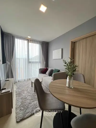 Modern living room with cozy seating and natural light, perfect for relaxation and entertainment.