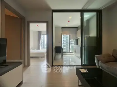 Modern apartment interior with open living room and kitchen, featuring sleek design and natural light.