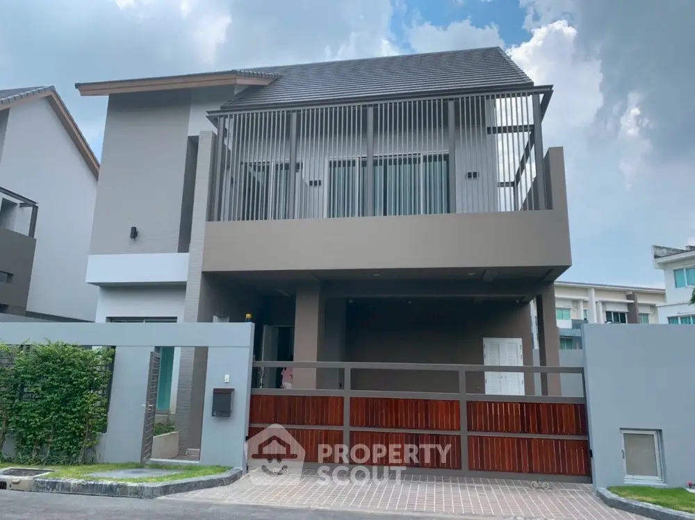 Modern two-story house with sleek design and spacious balcony in a suburban neighborhood.