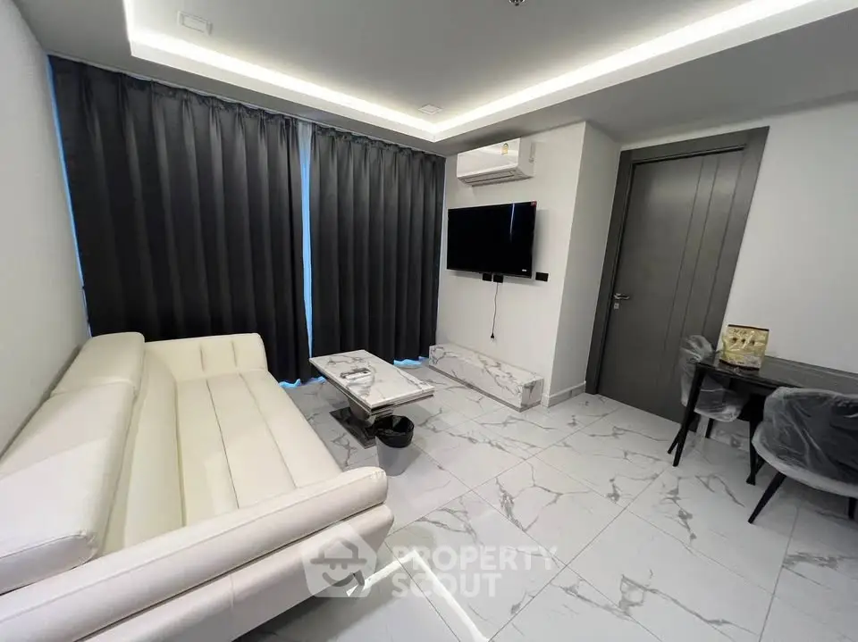 Modern living room with sleek white furniture and marble flooring