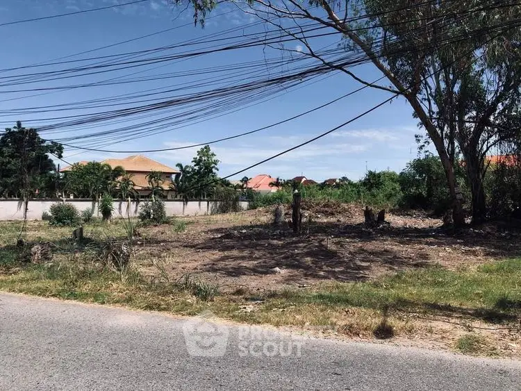 Vacant land plot with potential for development, surrounded by greenery and residential area.