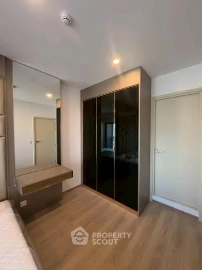 Modern bedroom with sleek wardrobe and wooden flooring