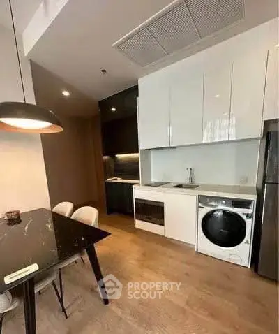 Modern kitchen with sleek cabinetry, integrated appliances, and stylish dining area.