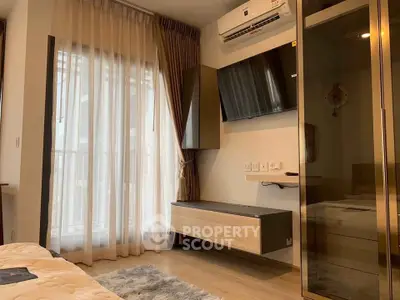 Modern bedroom with balcony access, featuring sleek furniture and air conditioning.