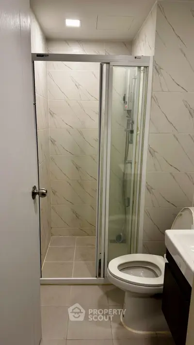 Modern bathroom with glass shower and sleek fixtures in a stylish real estate property.