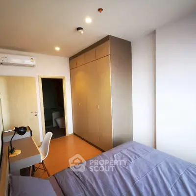 Modern bedroom with built-in wardrobe and study desk, featuring sleek design and ample natural light.