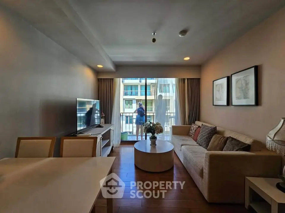 Modern living room with balcony view, stylish decor, and natural light.