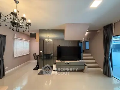 Modern living room with elegant chandelier and sleek TV setup