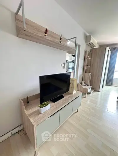 Modern living room with sleek TV stand and wall-mounted shelf, featuring stylish decor and ample natural light.