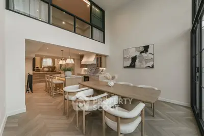 Stunning open-plan dining area with modern decor and high ceilings, perfect for entertaining.