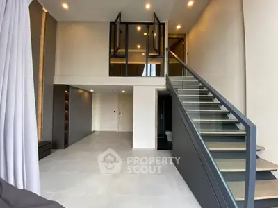 Modern duplex interior with sleek staircase and high ceilings, perfect for contemporary living.