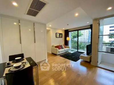 Modern living room with balcony, hardwood floors, and stylish decor in urban apartment.