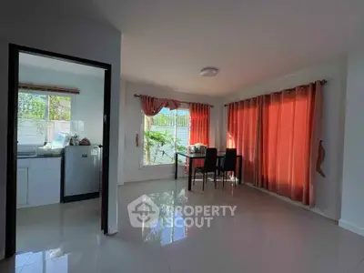Bright dining area with large windows and red curtains in modern home