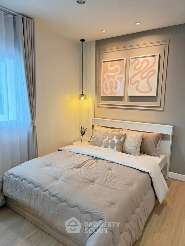 Cozy bedroom with modern decor and soft lighting, featuring a comfortable bed and stylish artwork.
