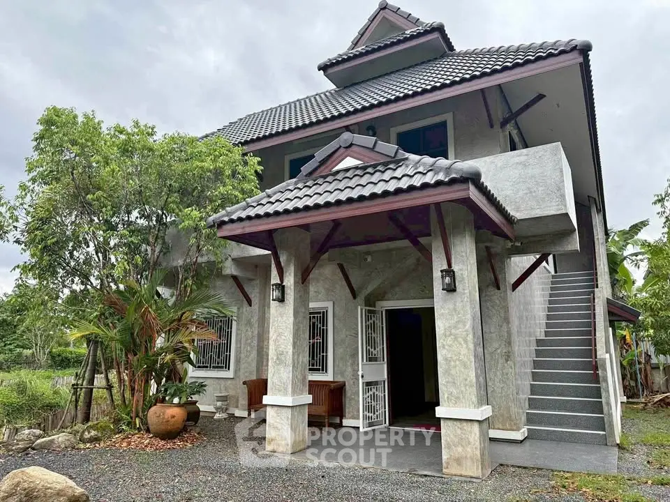 Charming two-story house with traditional roof and lush garden setting