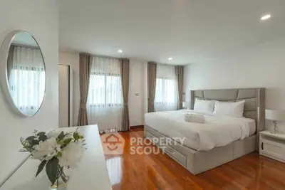 Spacious and elegant bedroom with hardwood floors and modern decor