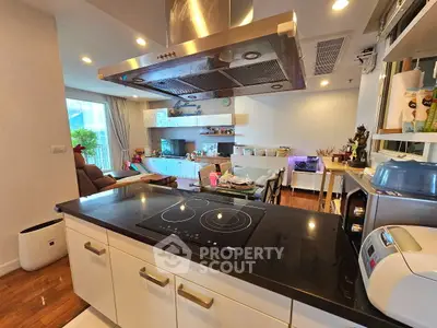 Modern open-layout kitchen with sleek appliances and cozy living area