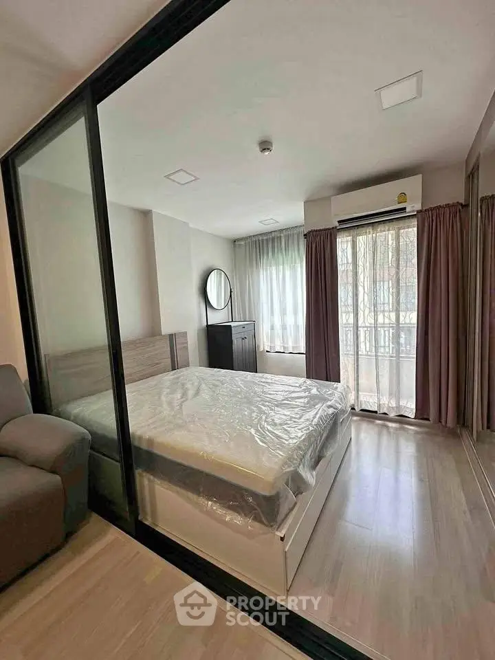 Modern bedroom with large windows and sliding glass doors, featuring a cozy bed and stylish decor.