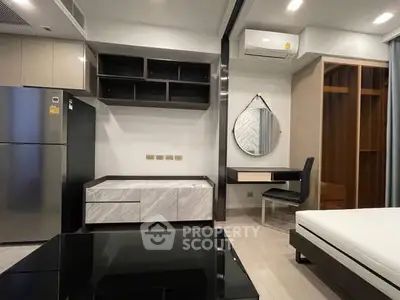 Modern studio apartment with sleek furniture and built-in storage solutions.