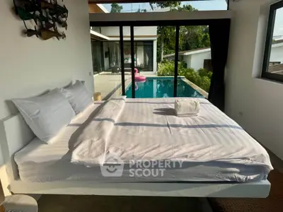Luxurious bedroom with pool view and modern design, perfect for relaxation and comfort.