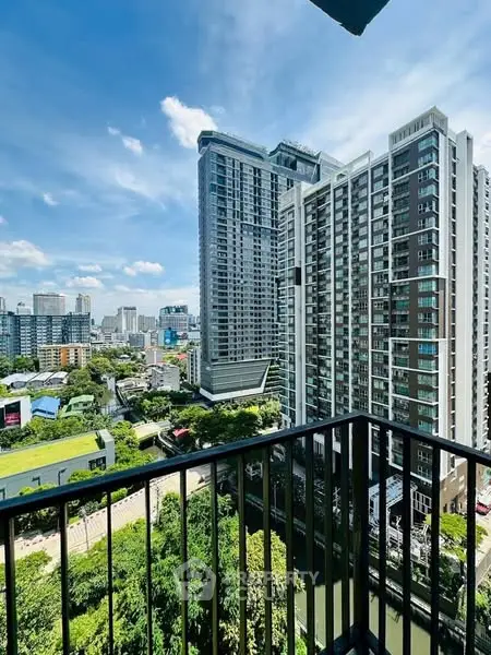 Stunning urban view from high-rise balcony overlooking city skyline and lush greenery.