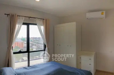 Spacious bedroom with city view and modern furnishings in high-rise apartment