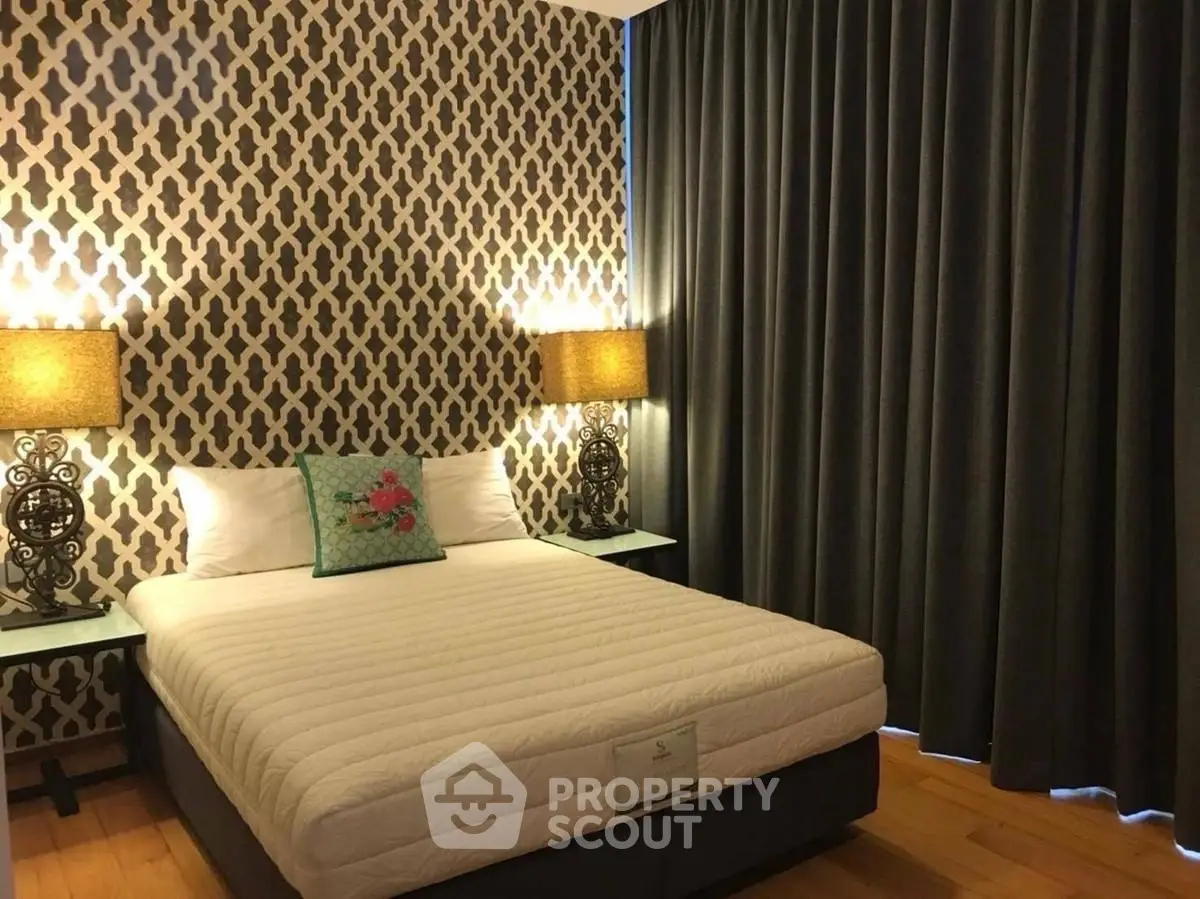 Cozy bedroom with stylish wallpaper and elegant lighting, perfect for relaxation.