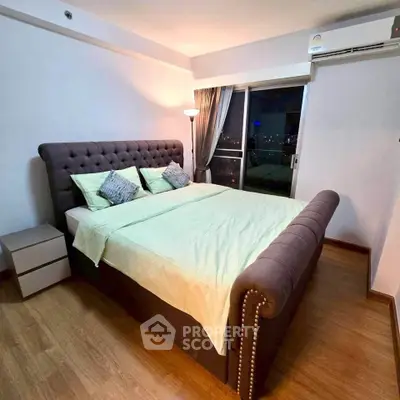 Spacious bedroom with elegant bed and city view from window, perfect for urban living.