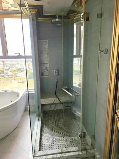 Luxurious bathroom with glass shower and freestanding bathtub, offering a serene view.